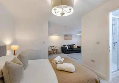 a bedroom with a bed and a living room at Lonsdale House Boutique Apartments in Ulverston