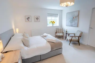 a bedroom with a bed and a table and chairs at Lonsdale House Boutique Apartments in Ulverston