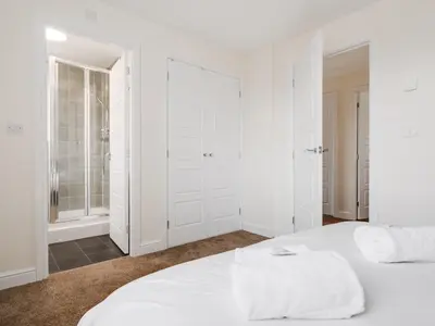 a white bedroom with a white bed and a shower at Modern and Cozy Kirkby Retreat Parking Sleeps 5 - Pass the Keys in Knowsley