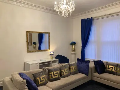 a living room with a couch and a mirror at AGAPI APARTMENT - SEA VIEW SLEEPS TEN in Blackpool