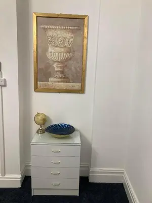a white dresser with a vase on top of it at AGAPI APARTMENT - SEA VIEW SLEEPS TEN in Blackpool