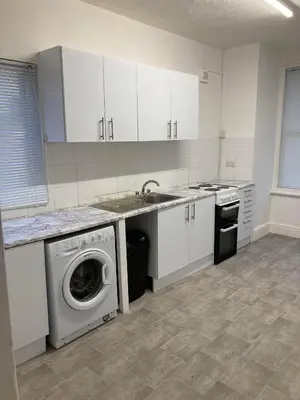 a kitchen with a sink and a washing machine at AGAPI APARTMENT - SEA VIEW SLEEPS TEN in Blackpool
