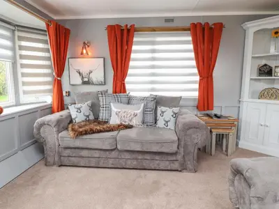 a living room with a couch and red curtains at Old Bell Farm in Preston