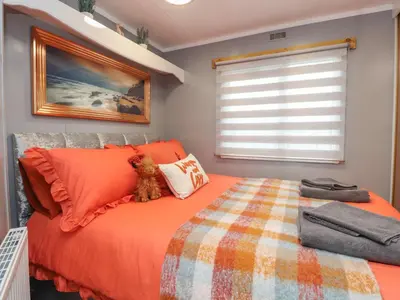 a bedroom with an orange bed and a window at Old Bell Farm in Preston