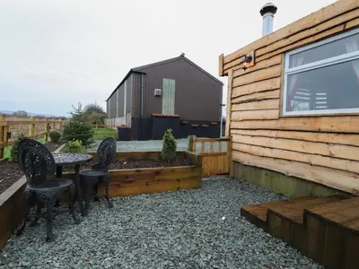 a patio with a table and chairs and a building at Old Bell Farm in Preston