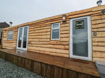 a log cabin with two windows and a wooden deck at Old Bell Farm in Preston