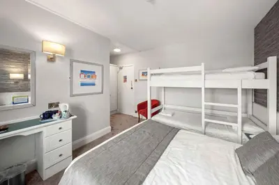 a bedroom with two bunk beds and a desk at Cliffs Hotel in Blackpool