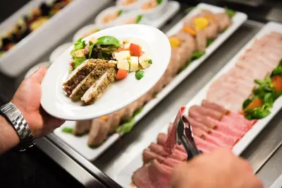 a group of people holding a plate of food at Cliffs Hotel in Blackpool