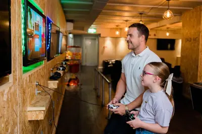 a man and a little girl playing a video game at Cliffs Hotel in Blackpool