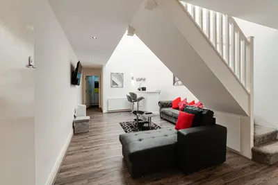 a living room with a couch and a staircase at Duke Street Apartment Hotel Liverpool City Centre in Liverpool