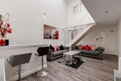 a living room with two couches and a staircase at Duke Street Apartment Hotel Liverpool City Centre in Liverpool