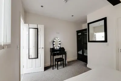 a bedroom with a vanity and a mirror and a table at Duke Street Apartment Hotel Liverpool City Centre in Liverpool