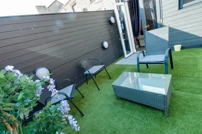 a patio with two chairs and a glass table at Duke Street Apartment Hotel Liverpool City Centre in Liverpool