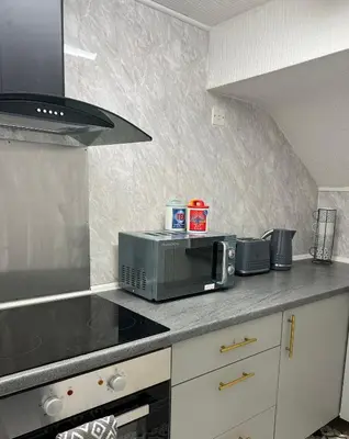 a kitchen with a counter top with a microwave at Quirky Attic Blackpool in Blackpool