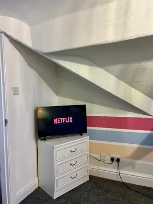 a tv sitting on top of a dresser in a bedroom at Quirky Attic Blackpool in Blackpool