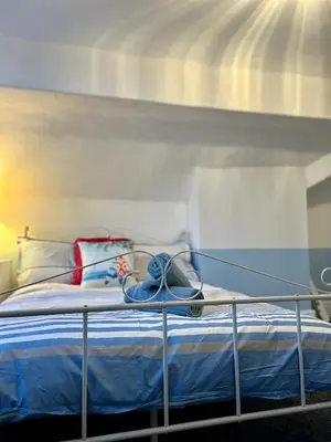 a bedroom with a bed with blue sheets at Quirky Attic Blackpool in Blackpool