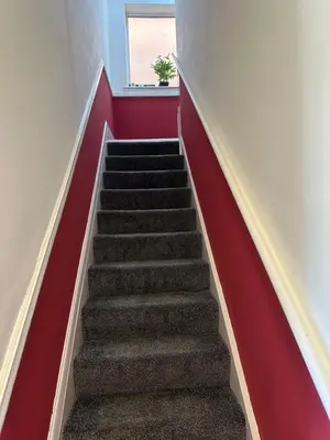 a stairway with a red wall and a red stair case at Quirky Attic Blackpool in Blackpool