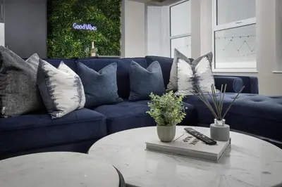 a blue couch with pillows and a table in a living room at The Blackpool Beach Boutique Apartments in Blackpool