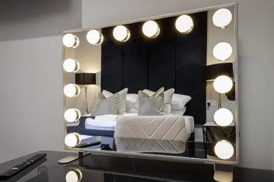 a mirror on a desk with a bed in a room at The Blackpool Beach Boutique Apartments in Blackpool