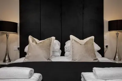 a bedroom with a bed with white pillows at The Blackpool Beach Boutique Apartments in Blackpool