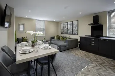 a living room with a table and a couch at The Blackpool Beach Boutique Apartments in Blackpool