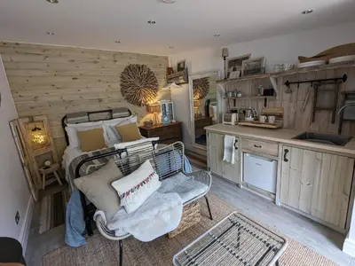 a living room with a bed and a kitchen at La Cachette in Blackpool