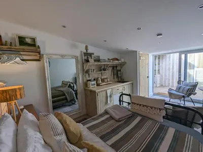 a living room with a couch and a mirror at La Cachette in Blackpool