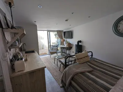 a bedroom with a bed and a living room with a table at La Cachette in Blackpool