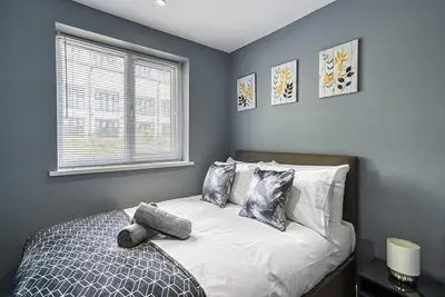 a bedroom with a bed with pillows and a window at Stylish 2 Bed Apartment with Free Parking in Preston