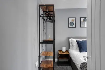 a bedroom with a black bunk bed next to a bed at Stylish 2 Bed Apartment with Free Parking in Preston