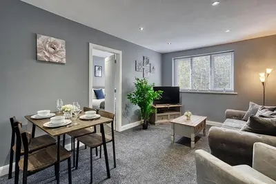 a living room with a table and a couch at Stylish 2 Bed Apartment with Free Parking in Preston