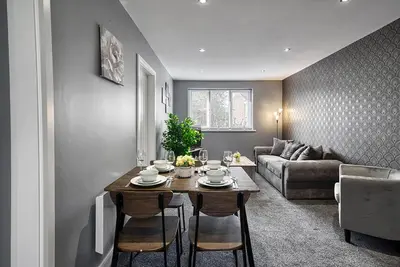 a living room with a table and a couch at Stylish 2 Bed Apartment with Free Parking in Preston