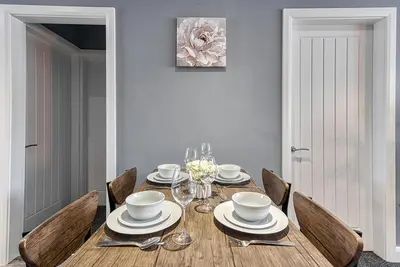 a dining room with a table with plates and bowls at Stylish 2 Bed Apartment with Free Parking in Preston