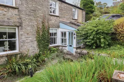 an old stone house with a blue door at 3 Tower View in Grange Over Sands