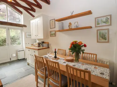 a kitchen with a table with a vase of flowers on it at 3 Tower View in Grange Over Sands
