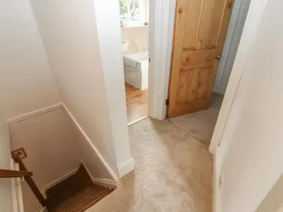 a hallway with a stairway with a door and a room at 3 Tower View in Grange Over Sands