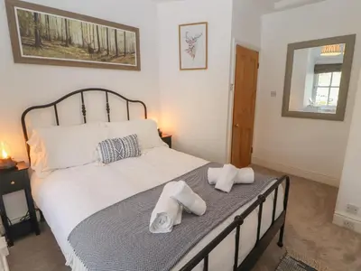 a bedroom with a bed with towels on it at 3 Tower View in Grange Over Sands