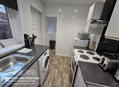 a kitchen with a sink and a washing machine at 16 Newcastle street by Prestige Properties Serviced Accommodation in Barrow in Furness
