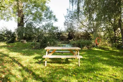 a picnic table sitting in the grass in a field at Large converted barn in peaceful, rural location in Hambleton