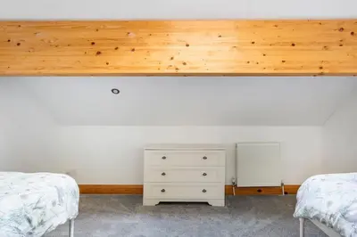 a bedroom with two beds and a white dresser at Large converted barn in peaceful, rural location in Hambleton