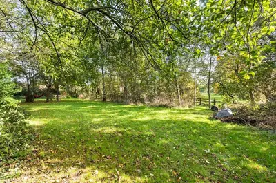a park with green grass and trees and a bench at Large converted barn in peaceful, rural location in Hambleton