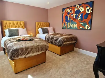 a bedroom with two beds and a painting on the wall at The Hamilton Luxury Let-The Duke in Scorton