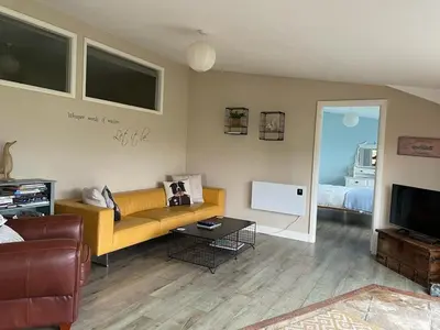 a living room with a yellow couch and a television at Let It Be in Liverpool