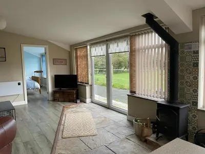 a living room with a fireplace and some windows at Let It Be in Liverpool