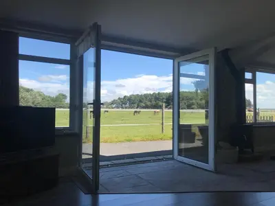 an open glass door with a view of a field at Let It Be in Liverpool