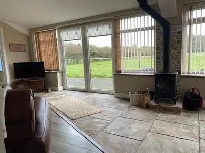 a living room with a fireplace and large windows at Let It Be in Liverpool