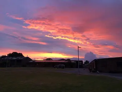 a sunset with a car parked in a parking lot at Strawberry Fields in Liverpool