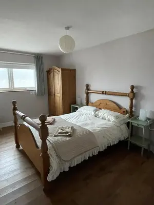 a bedroom with a large bed with a wooden frame at Strawberry Fields in Liverpool