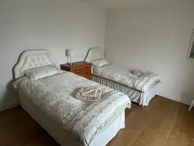 a bedroom with two beds and a dresser and a lamp at Strawberry Fields in Liverpool