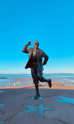 a statue of a man standing on the beach at Eden Stay 5 Bedroom House in Morecambe